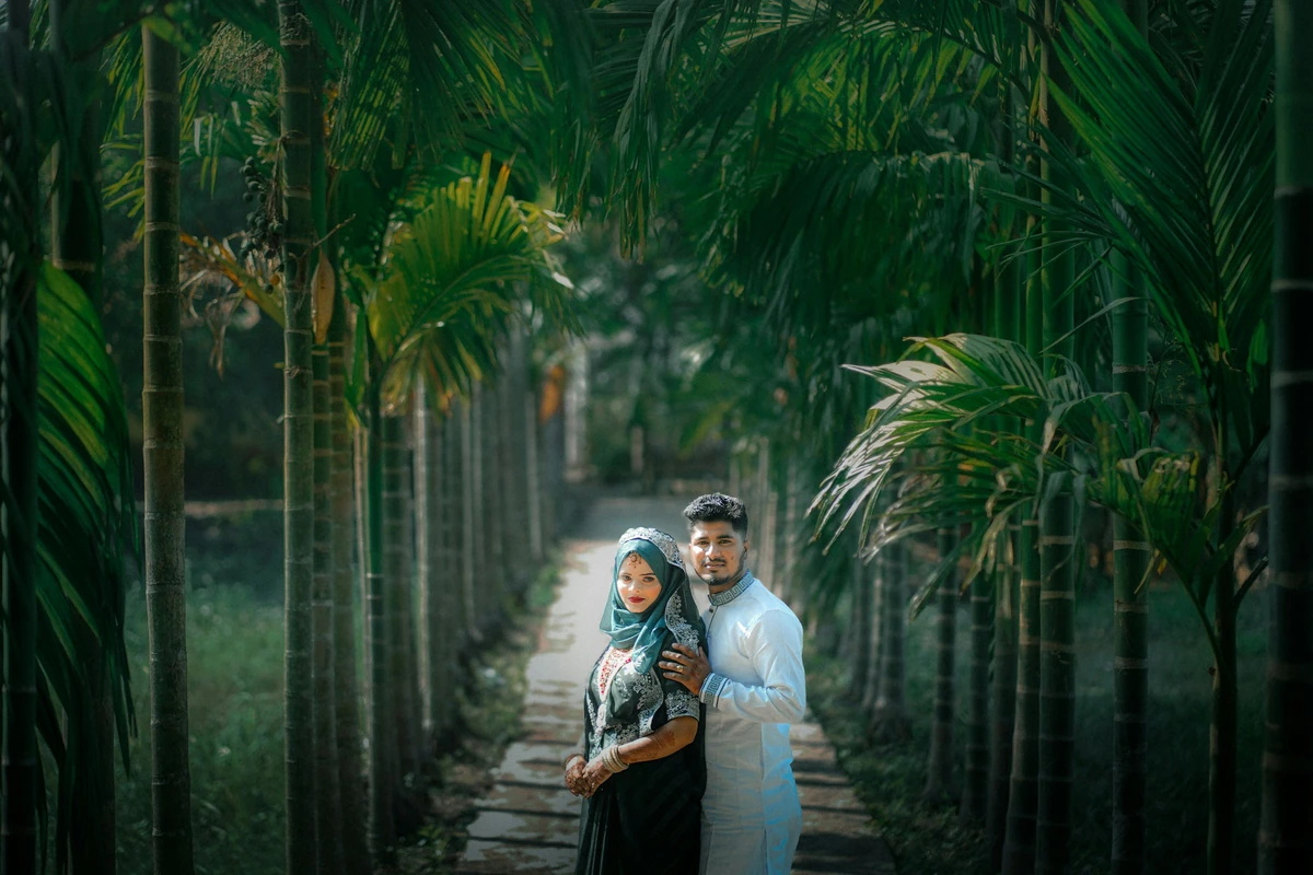 Pasangan berjalan di taman palem; foto stok